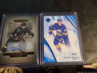 Front views of both hockey cards in top-loaders