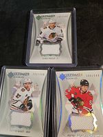 All three Upper Deck Ultimate Rookies jersey swatch cards in top loaders