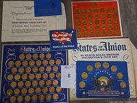 Group shot showing both coin boards, booklets, and certificate envelope