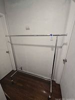 Full frontal view of chrome garment rack showing width and casters