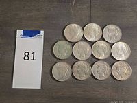 Group of 11 Peace dollars laid out on table
