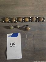 bracelet, ring and earrings arranged on table