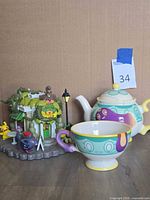 Group shot showing teapot, teacup and Creeping Vine Teashop figure