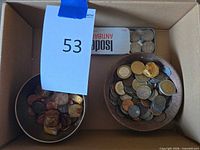 overview of box with two bowls of coins and metal tin