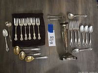 Flatware set and candlestick arranged to show quantity and pattern