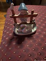 Front view showing entire figurine with child, fence, swan