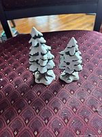 Front view of both ceramic snow-tipped trees standing side by side