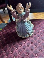 Front view of ceramic girl figurine on chair