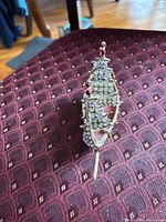 Side view of gold-tone rhinestone ship brooch
