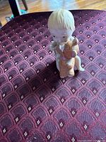 Front view of baby figurine holding teddy