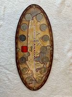 Front of oval display showing 12 coins mounted