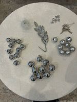 Group view of all silver ornaments, bells, pick, wire sphere and reindeer