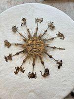 Full view of round metal sun wall hanging with zodiac figures
