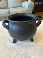 Front view of matte black ceramic cauldron-style planter bowl