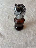 Bottle standing upright showing chrome horse head stopper
