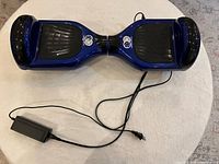 Top view of blue hoverboard with charger attached