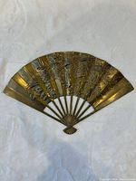 Full view of brass fan plaque front with phoenix and floral relief