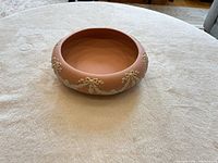 Oblique view of pink ceramic bowl showing exterior relief decoration