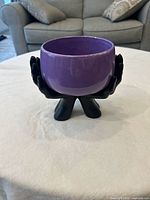 Bowl resting in hand-shaped stand