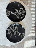 Top view of both black platters showing white spider web design