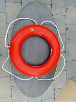 Full view of orange lifebuoy with white rope showing overall form and size