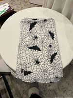 Tablecloth folded on table showing bat, spider and web pattern