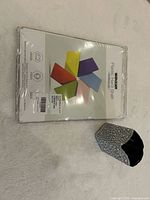 Front view of sealed iBenzer hard shell packaging beside rhinestone holder