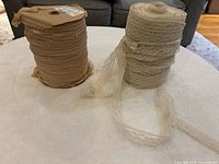 Two spools of lace trim, beige left, ivory right