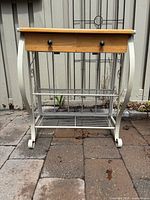 Front view showing wood top, two drawers, metal frame, wire shelves