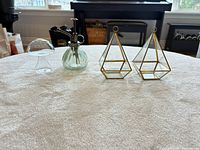 Front view of all four items: two geometric terrariums, glass mister, glass cloche