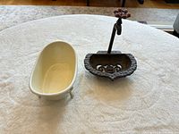 Miniature bathtub beside cast iron soap dish with faucet