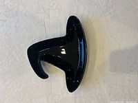 Top view of glossy black ceramic dish showing overall freeform tri-wing shape