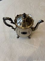 Full view of teapot showing lid, handle, spout and feet