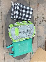 All three items—folded blanket, collapsed basket, seat cushion—on table