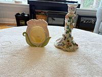 Overall view of porcelain candlestick and ceramic picture frame on table
