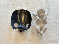 Front view of both items: black ceramic eyeglass holder and white angel figurine
