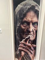 Hooded elderly figure pointing on polyester door cover
