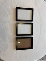 Front view of three black 5x7 frames with glass inserts