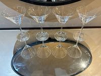 Six martini glasses displayed in two rows on mirrored surface