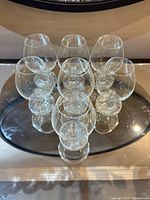 Set of seven identical clear brandy snifters shown from overhead angle