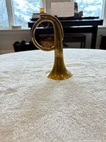 Side view showing entire brass post horn and polished finish