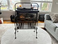 Front view of wrought iron magazine rack on round table