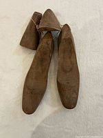 Top view of two wooden shoe lasts showing wear on uppers and attached heel blocks