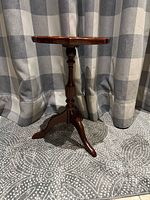 Full view of pedestal side table showing legs and overall form