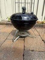 Side view of assembled Weber 14-inch charcoal kettle grill with ash catcher