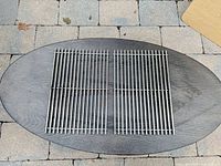 Two Weber stainless steel grill grates on table overview