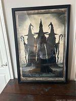 Full view of framed witches Halloween print in black frame under glass