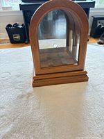 Front view of arch-top wood display case with glass panels