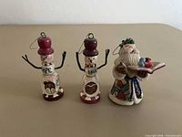 Front view of two snowmen ornaments and Santa figurine