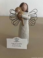 Front view of Angel of Friendship figurine with title card visible